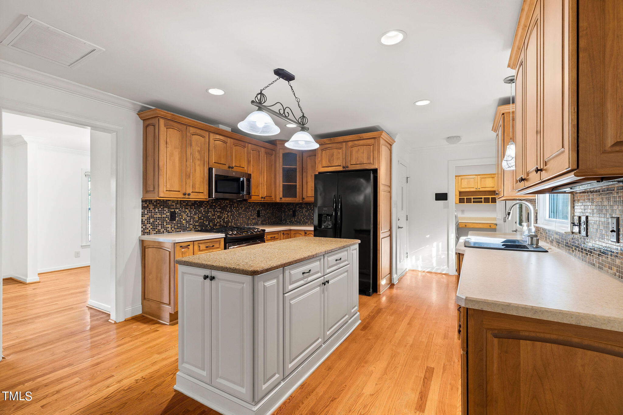 6131 Yellowstone Drive Durham, NC 27713 - Photo 10 of 29 a kitchen with a refrigerator a sink dishwasher and a stove with wooden floor