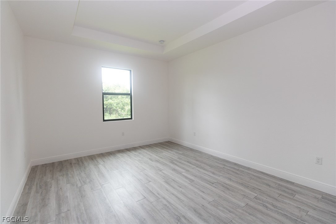 3032 West Briarwood Road LaBelle, FL 33935 - Photo 16 of 23 an empty room with wooden floor and windows