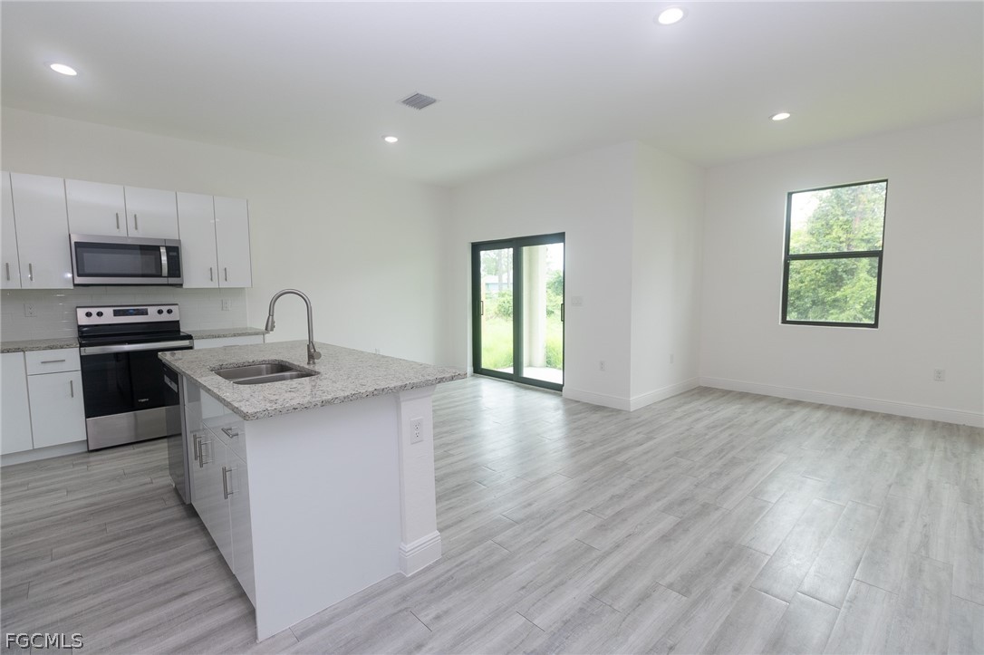 3032 West Briarwood Road LaBelle, FL 33935 - Photo 4 of 23 a kitchen with granite countertop a stove and a wooden floors