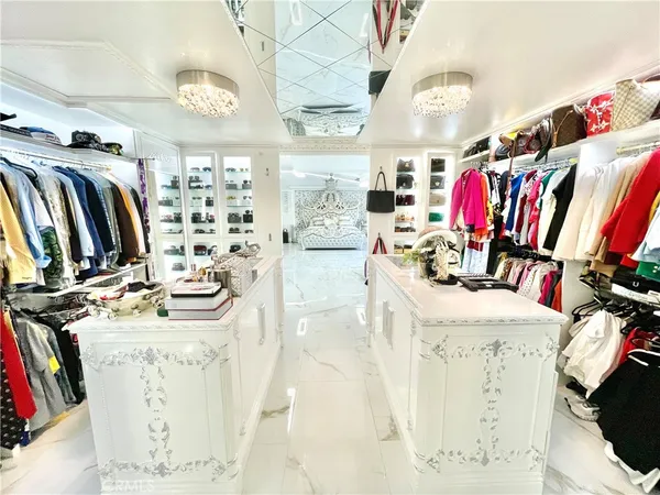 a view of walk in closet with clothes and shoes