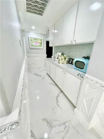 a kitchen with white cabinets and sink