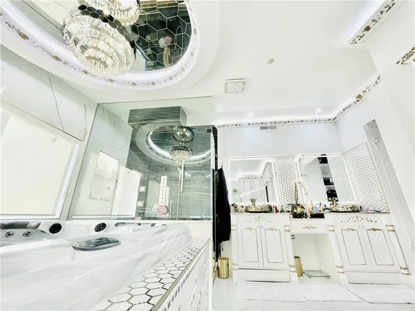 a large white kitchen with a large mirror and a large window