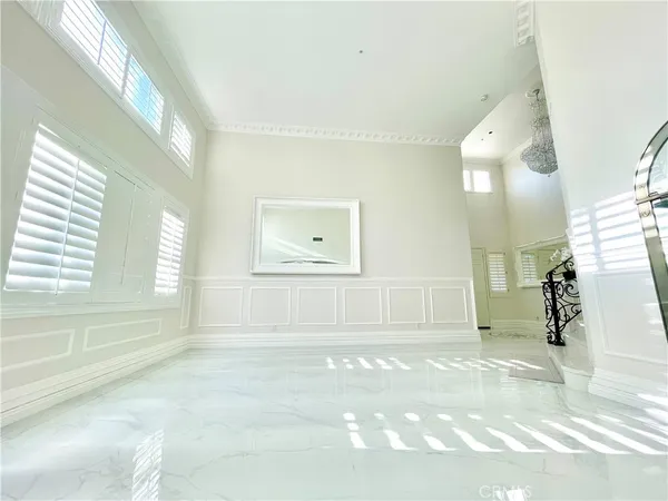 a view of a hallway with windows and chandelier