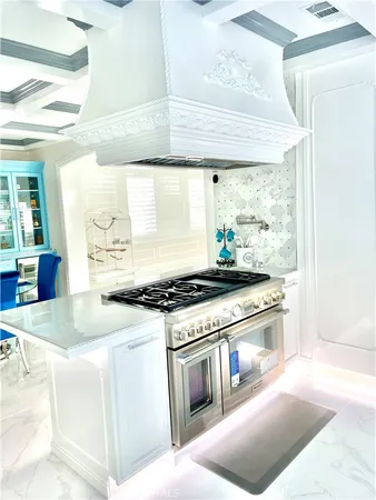a kitchen with stainless steel appliances granite countertop a stove and a white cabinet with granite countertops