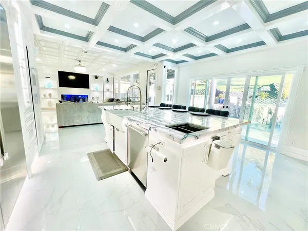 a kitchen that has a sink and a stove with the view of living room