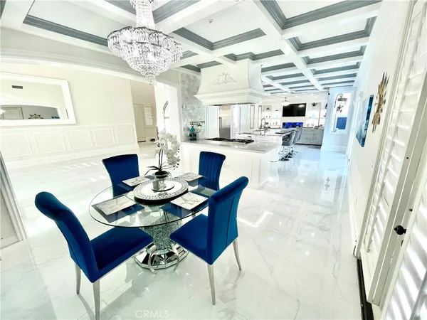 a dining room with furniture a chandelier and wooden floor