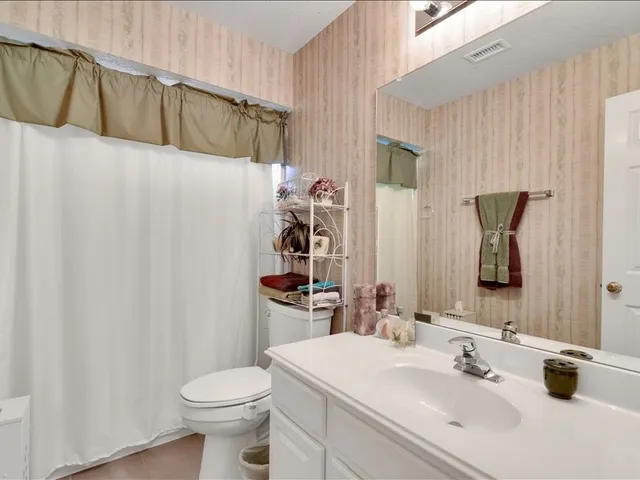 a bathroom with a sink toilet vanity and shower