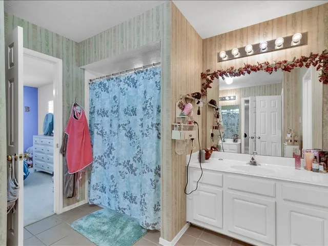a bathroom with a double vanity sink mirror and shower