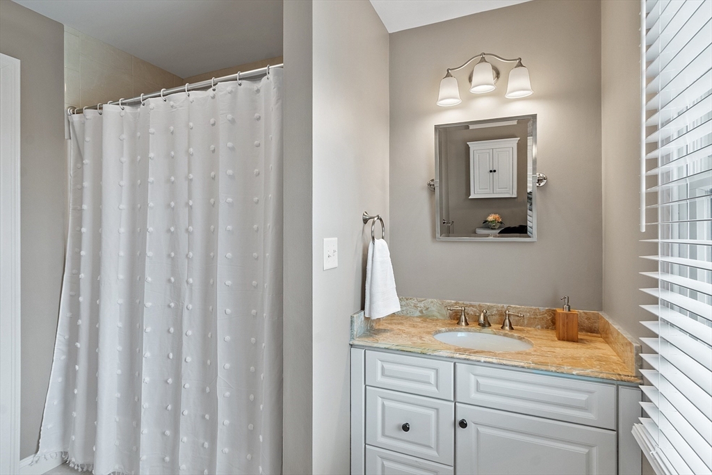 35 Lancaster County Road, Unit 7C Harvard, MA 01451 - Photo 23 of 33 a bathroom with a granite countertop sink and a mirror