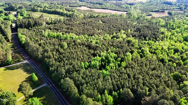 an aerial view of residential houses with outdoor space and trees