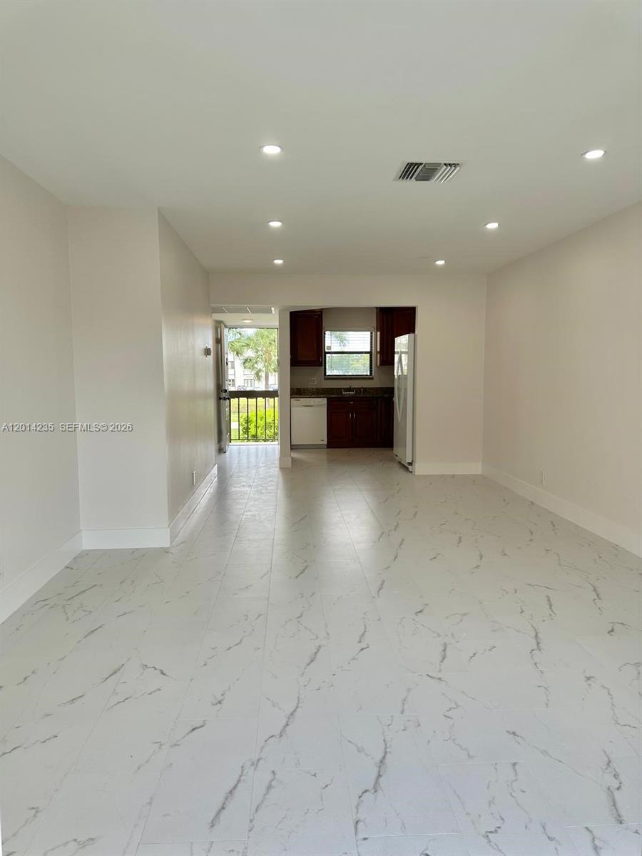 21911 Lake Forest Circle, Unit 202 Boca Raton, FL 33433 - Photo 2 of 14 an empty room with fireplace and windows