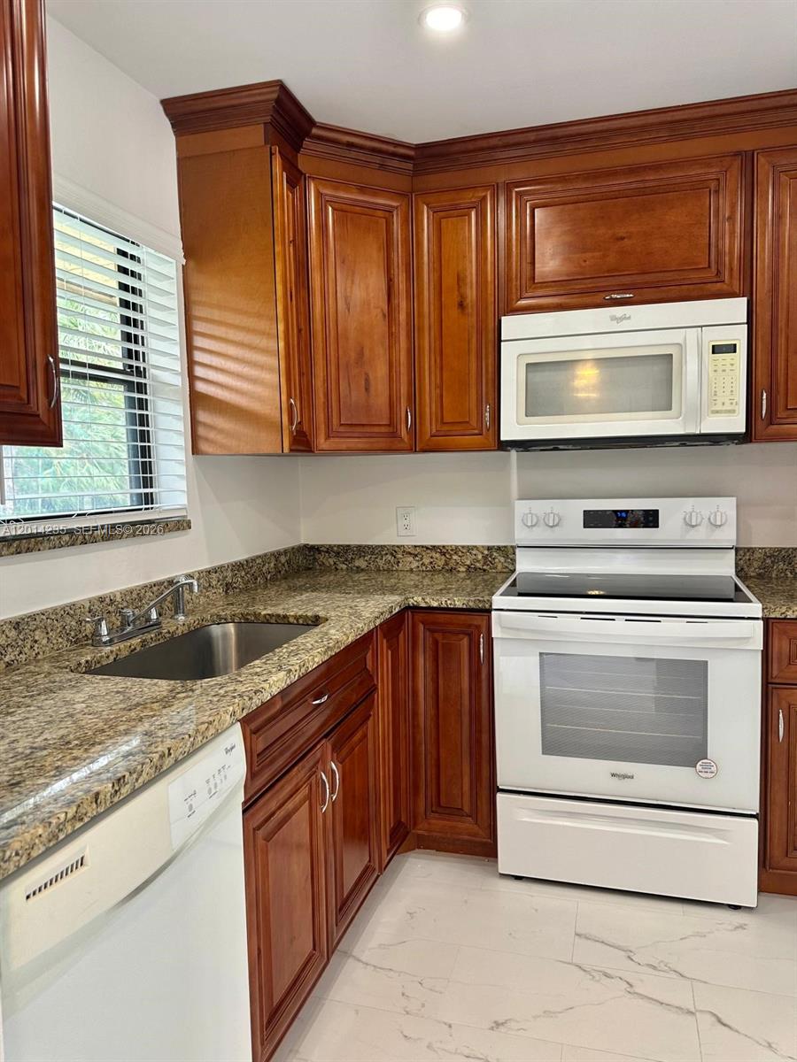 21911 Lake Forest Circle, Unit 202 Boca Raton, FL 33433 - Photo 3 of 14 a kitchen with granite countertop a sink and a stove