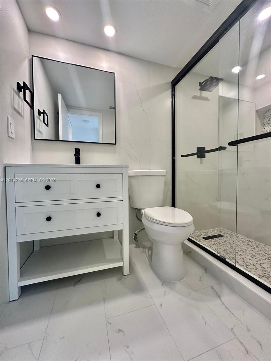 21911 Lake Forest Circle, Unit 202 Boca Raton, FL 33433 - Photo 9 of 14 a bathroom with a toilet sink and mirror