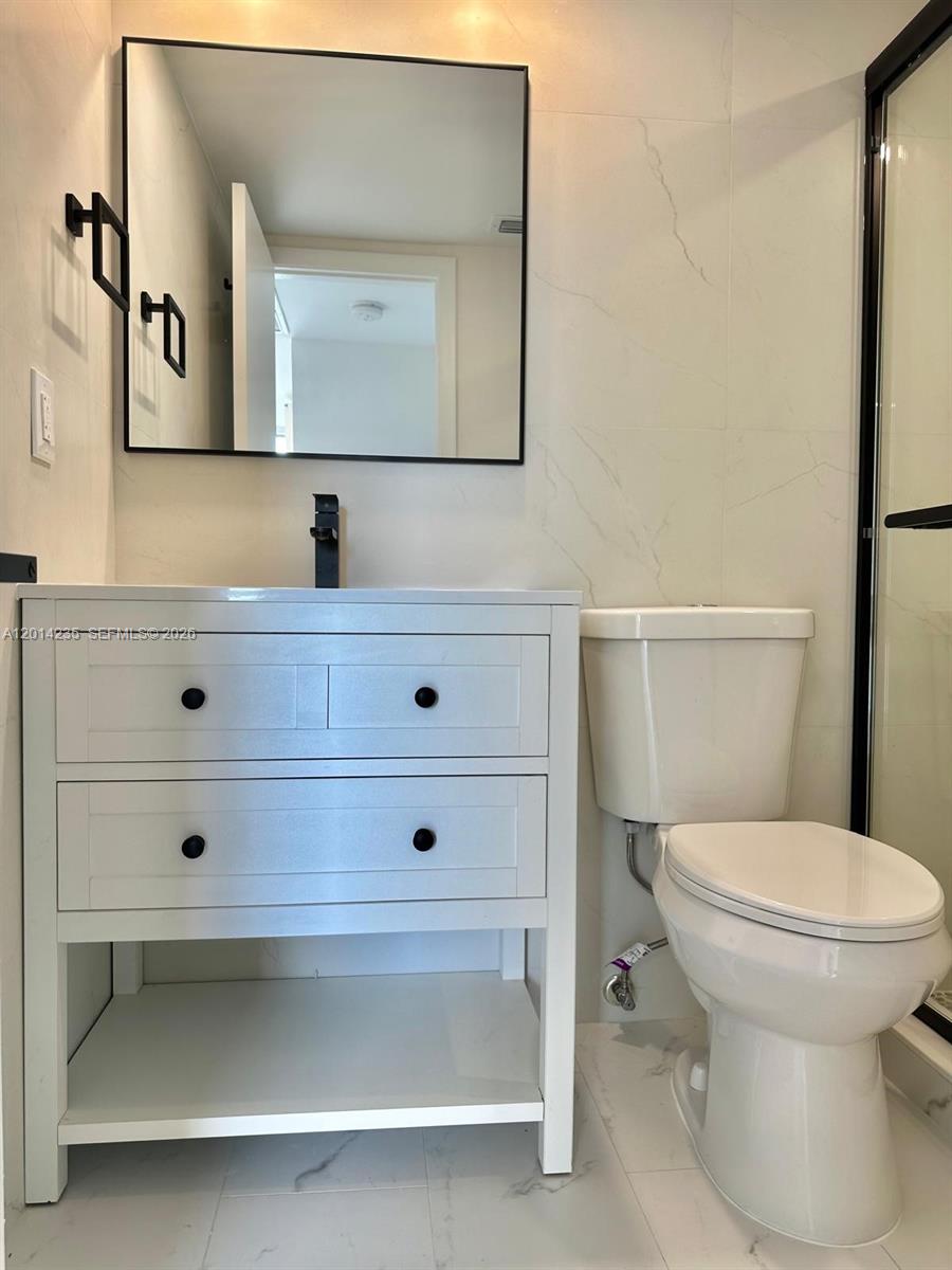 21911 Lake Forest Circle, Unit 202 Boca Raton, FL 33433 - Photo 10 of 14 a bathroom with a toilet sink and mirror