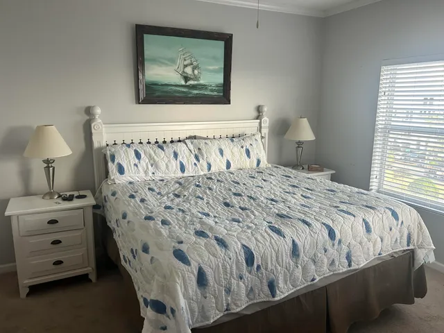 a bedroom with a bed and a lamp on dresser