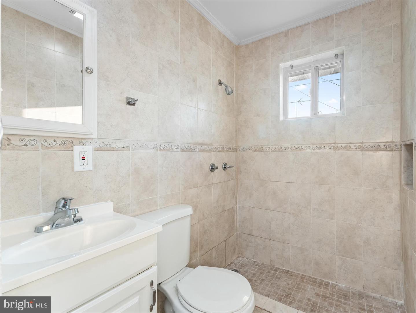 252 G Street Carneys Point, NJ 08069 - Photo 3 of 8 a bathroom with a sink toilet a mirror and shower