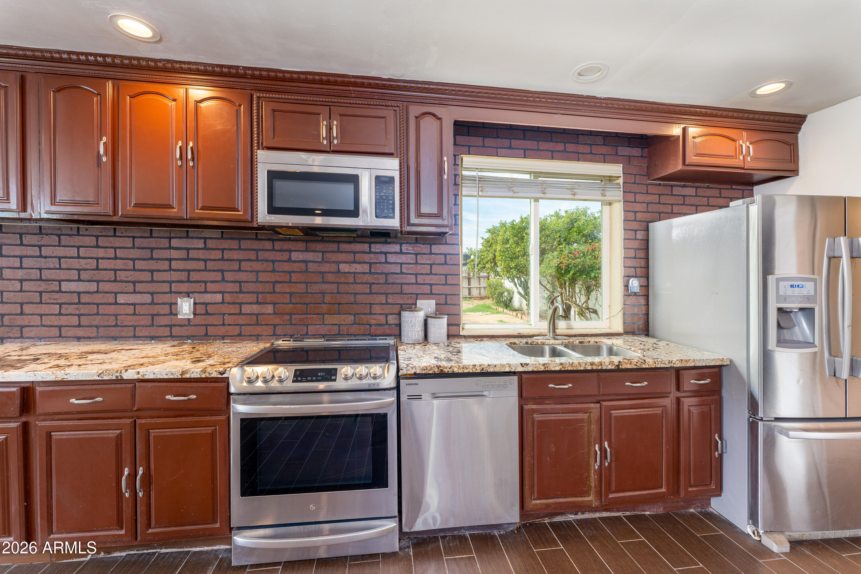 9616 North 11th Avenue Phoenix, AZ 85021 - Photo 23 of 32 a kitchen with granite countertop a stove top oven microwave and refrigerator