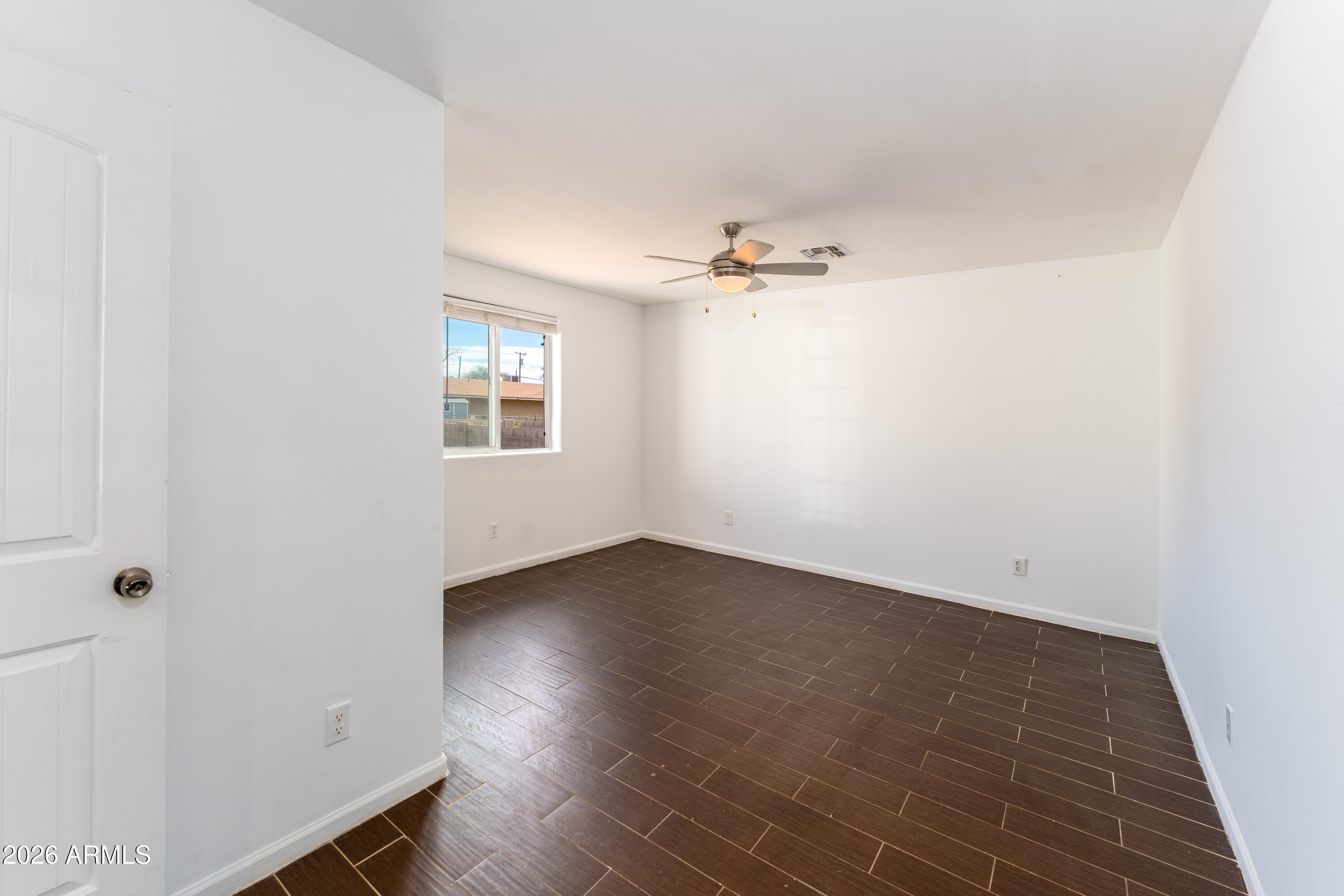 9616 North 11th Avenue Phoenix, AZ 85021 - Photo 10 of 32 an empty room with wooden floor and windows