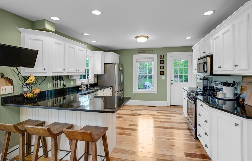 194 Washington Street Boxford, MA 01921 - Photo 6 of 35 a kitchen with stainless steel appliances granite countertop a stove top oven a sink a dining table and chairs