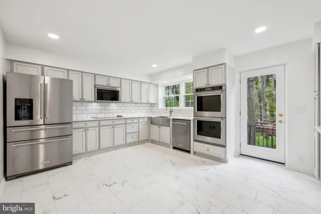 a kitchen with stainless steel appliances a refrigerator sink and stove
