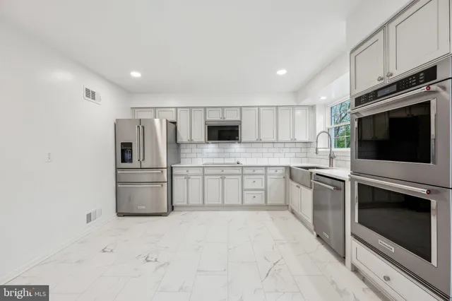 a kitchen with stainless steel appliances a refrigerator stove microwave and sink