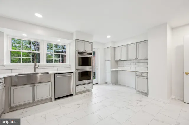 a kitchen with white cabinets and sink