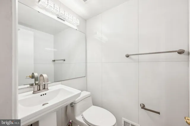 a bathroom with a toilet a sink a mirror and vanity