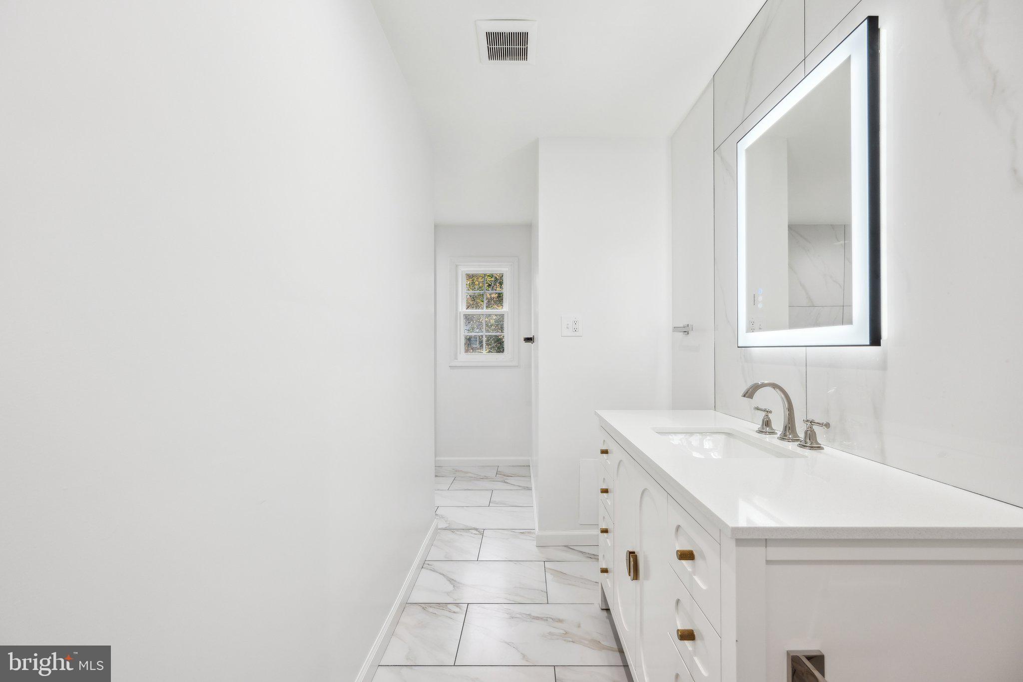 2827 Ellicott Street Northwest Washington, DC 20008 - Photo 39 of 56 a bathroom with a sink a toilet and mirror