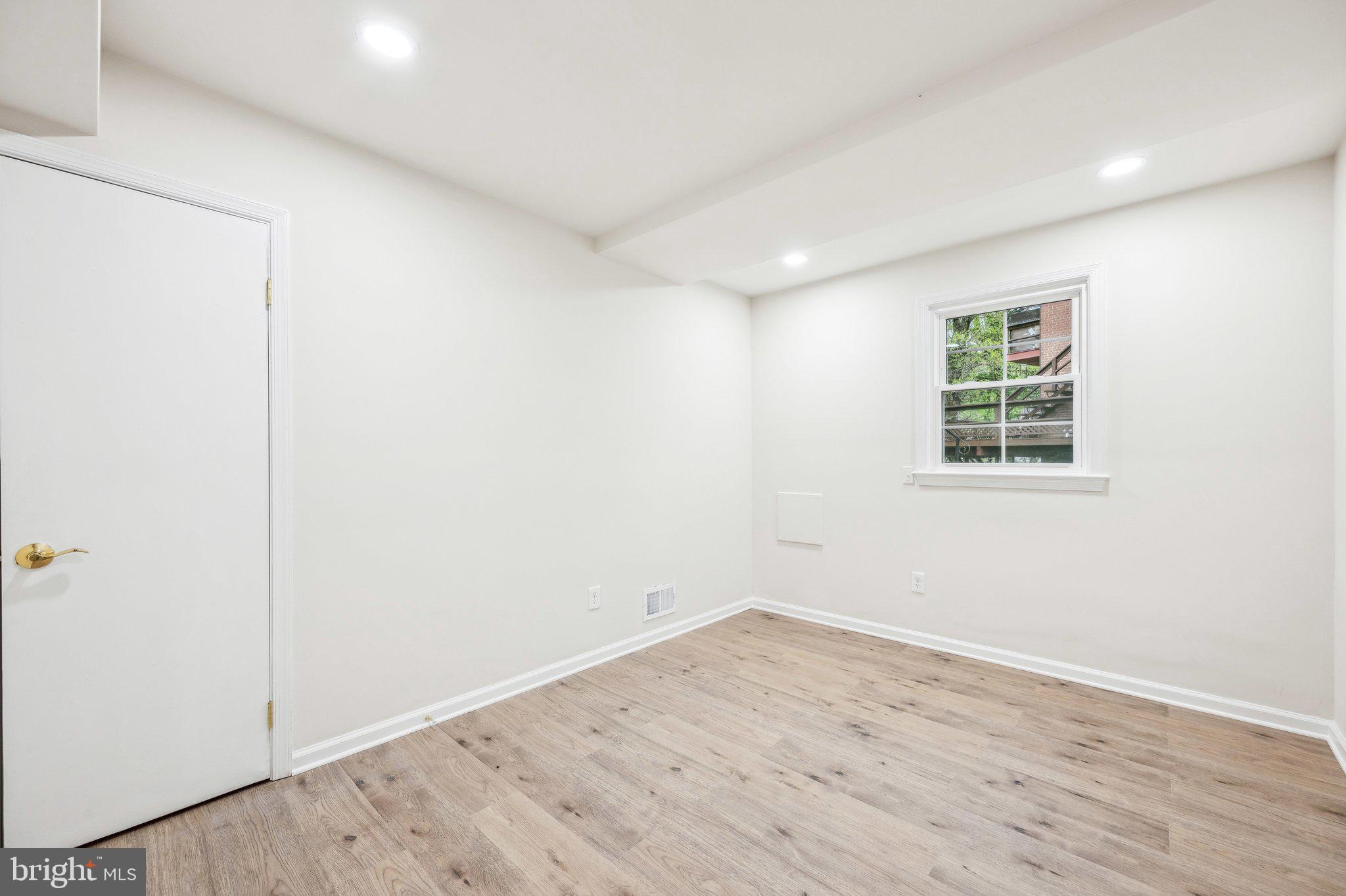 2827 Ellicott Street Northwest Washington, DC 20008 - Photo 46 of 56 an empty room with wooden floor and windows