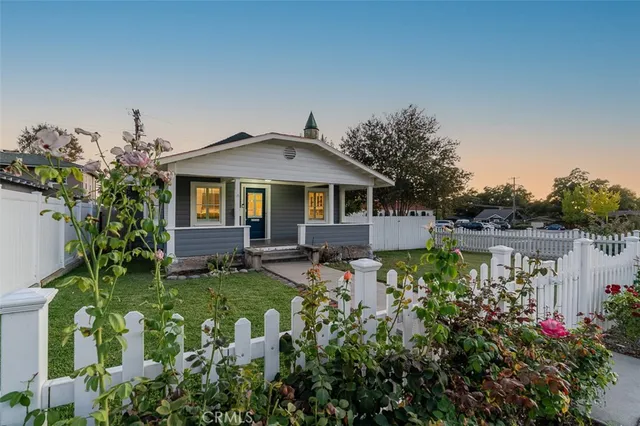 a front view of a house with a garden and trees