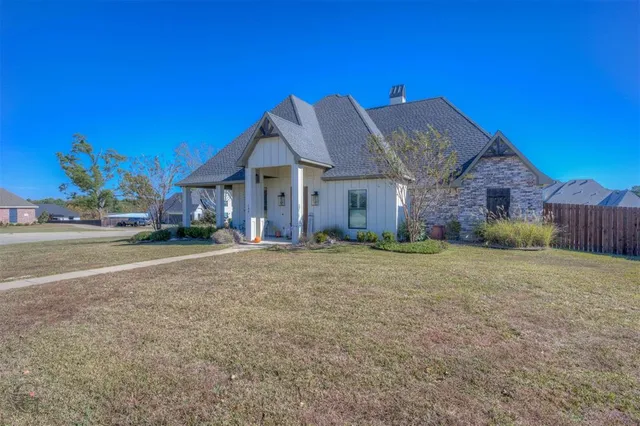 a view of a big house with a big yard and large tree
