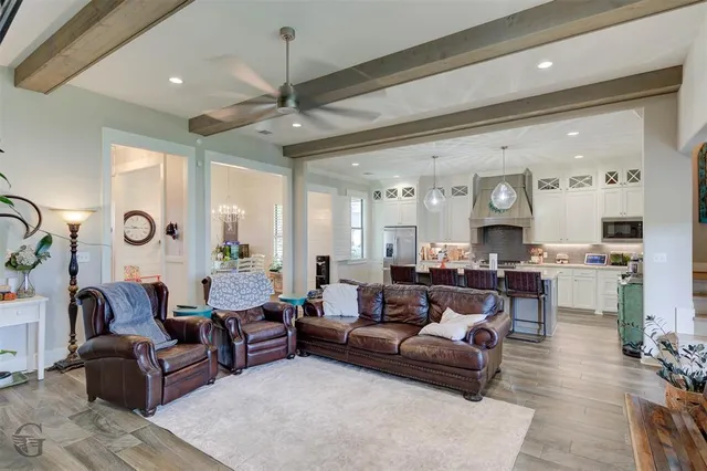 a living room with furniture kitchen view and a chandelier