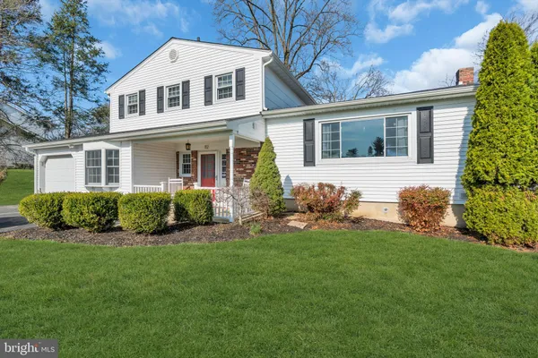 a front view of a house with a garden and plants