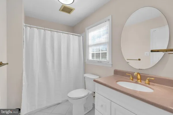 a bathroom with a granite countertop sink toilet and a mirror