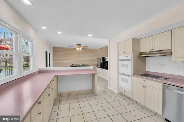 a kitchen with white cabinets appliances and a sink