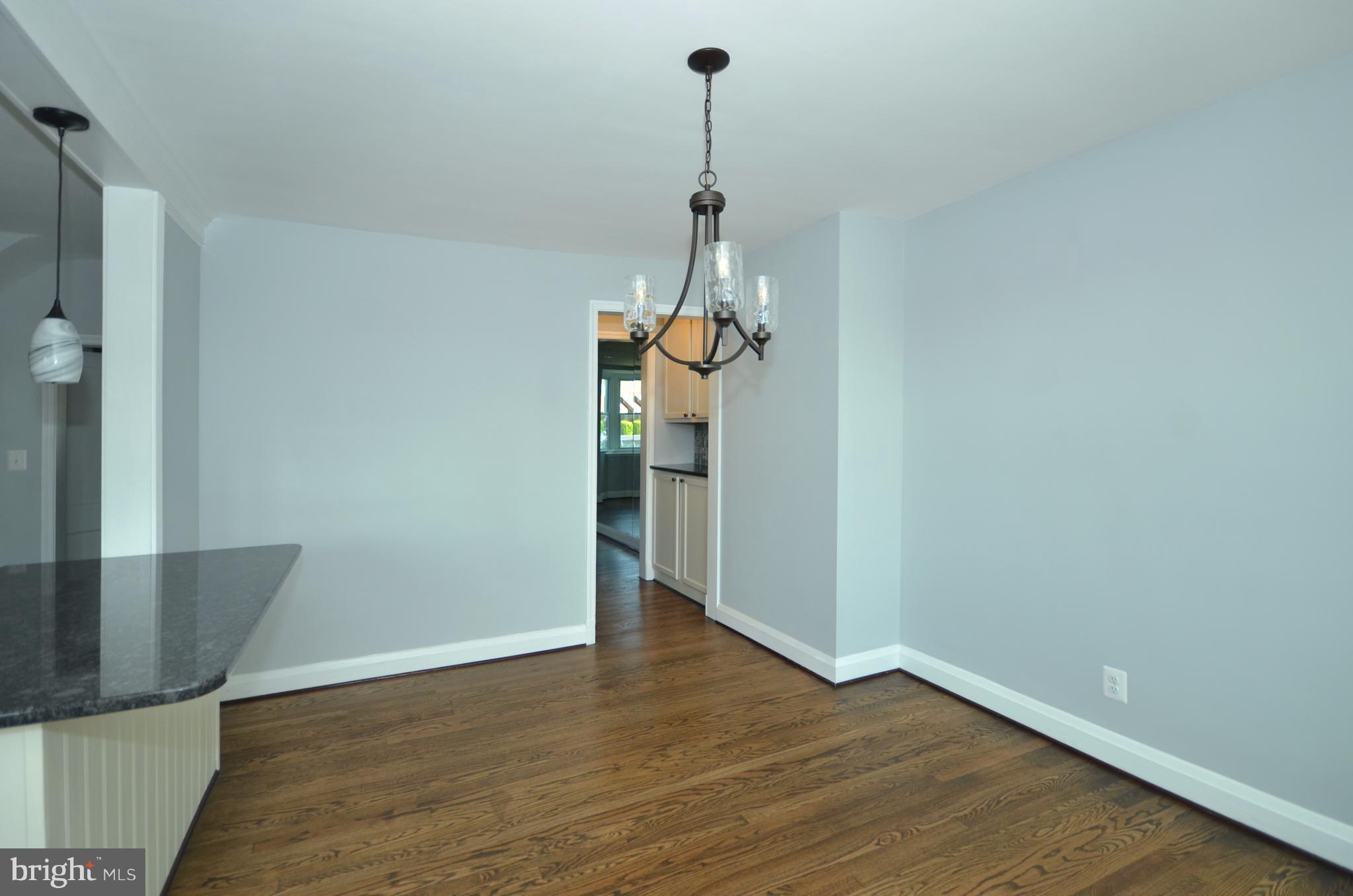 1527 Sheffield Road Baltimore, MD 21218 - Photo 8 of 28 a view of a room with wooden floor and a chandelier