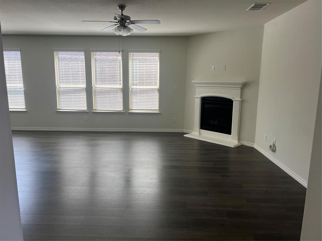 1821 Ferguson Lane McKinney, TX 75071 - Photo 6 of 26 an empty room with wooden floor fireplace and windows