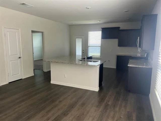 a kitchen with stainless steel appliances granite countertop a refrigerator and a stove top oven