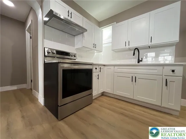 a kitchen with stainless steel appliances granite countertop a stove a sink and a microwave