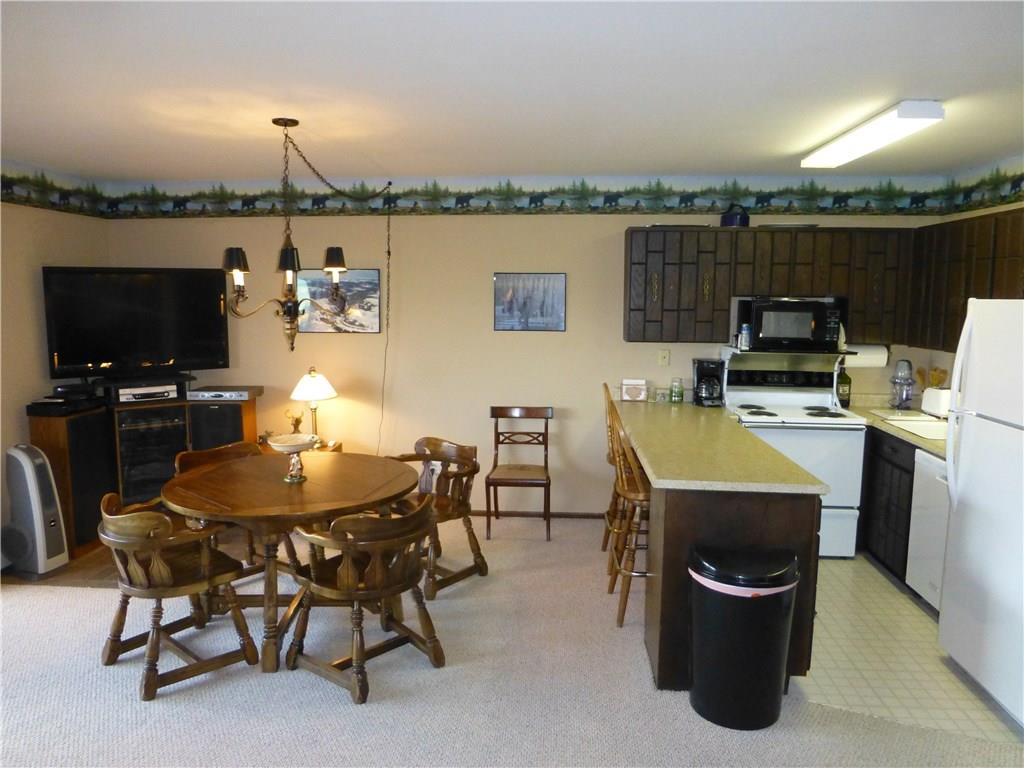110 Evergreen Road, Unit B303 Dillon, CO 80435 - Photo 19 of 21 a dining room with furniture a chandelier and a flat screen tv