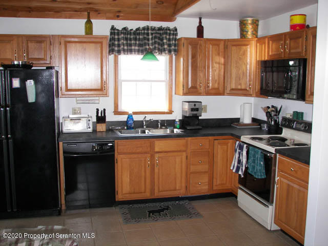 204 Scott Road Union Dale, PA 18470 - Photo 3 of 14 a kitchen with granite countertop a sink stove and refrigerator