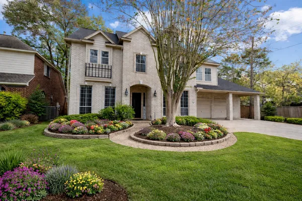 a front view of a house with a garden and plants