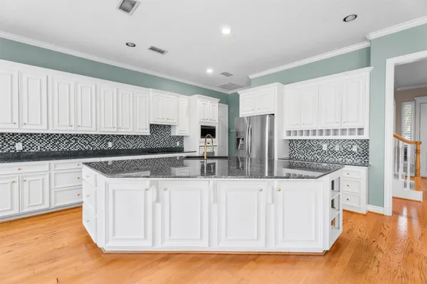a kitchen with granite countertop a white sink and cabinets