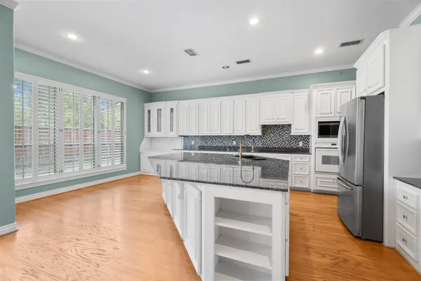a kitchen with stainless steel appliances granite countertop a refrigerator sink and cabinets