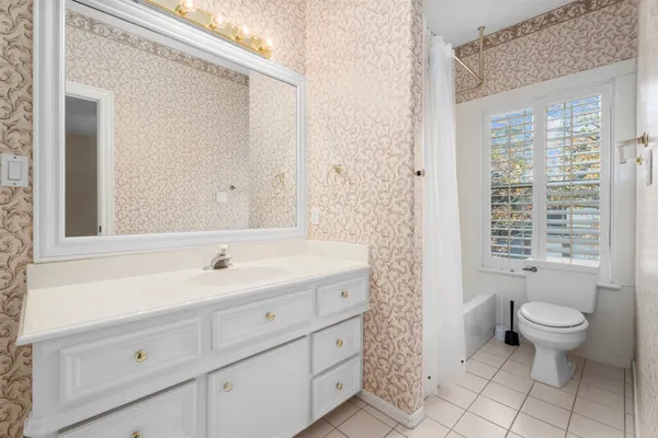 a spacious bathroom with a granite countertop sink a toilet and a mirror