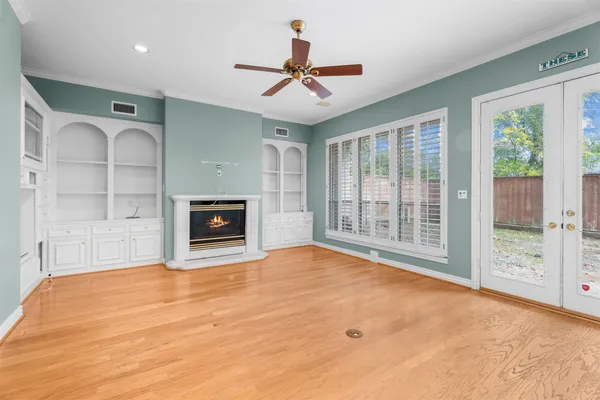 a view of an empty room with a fireplace and a window