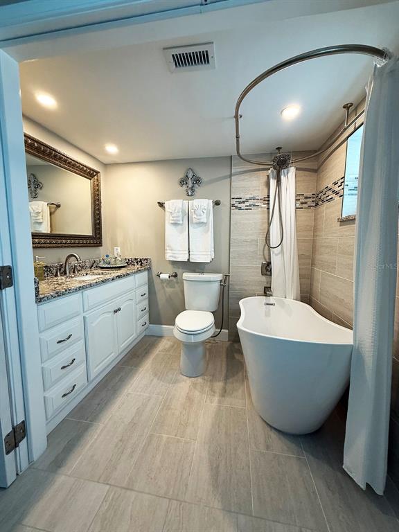 4455 Duhme Road, Unit 103 St. Petersburg, FL 33708 - Photo 21 of 37 a spacious bathroom with a double vanity sink a mirror and a bathtub
