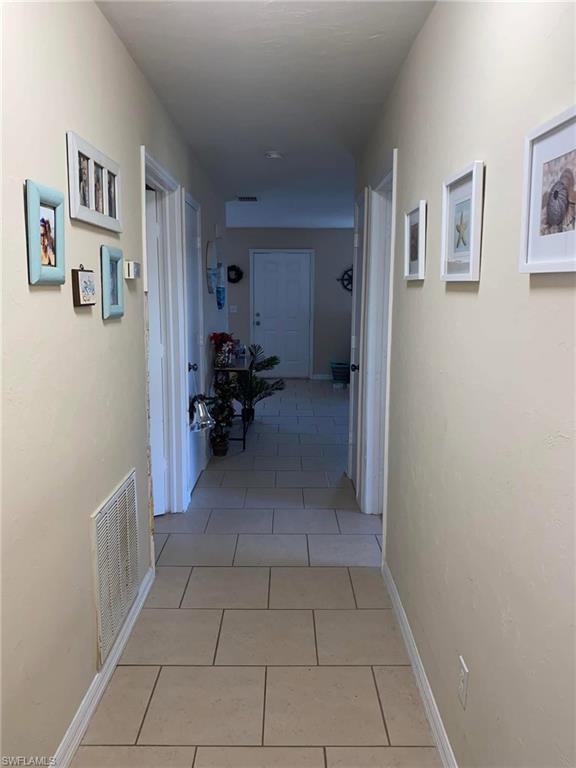 4204 34th Street Southwest Lehigh Acres, FL 33976 - Photo 5 of 8 a view of hallway with furniture and a refrigerator