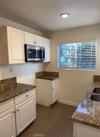 a kitchen with granite countertop a sink and a stove
