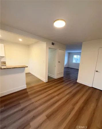 an empty room with wooden floor and entrance